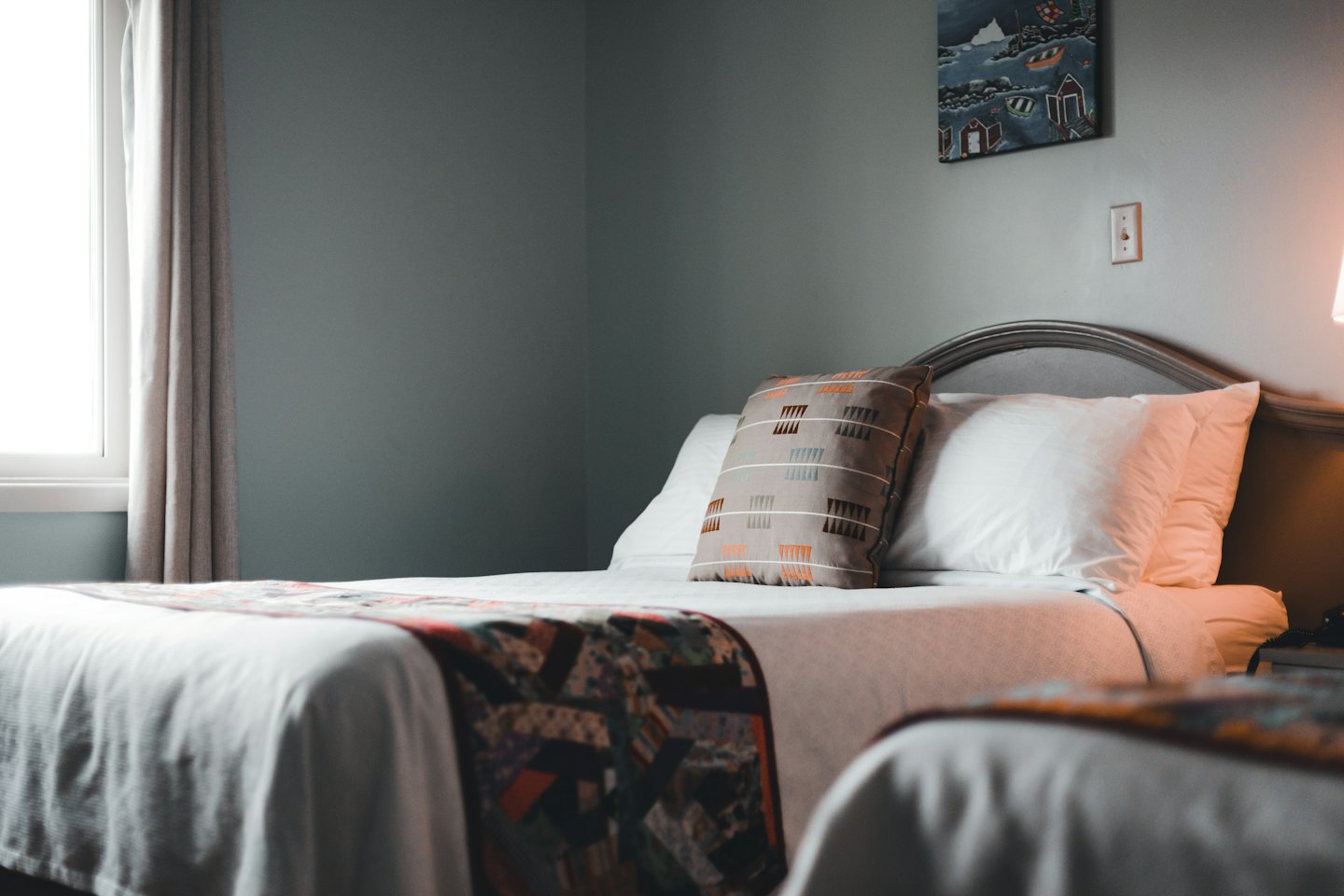 Deux lits d'hôtel avec draps blancs et oreillers décoratifs.