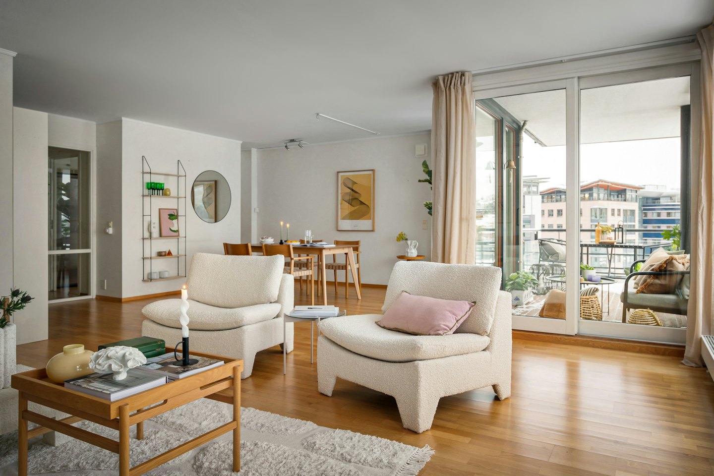 Espace de vie et salle à manger d'un appartement moderne avec fauteuils et tables en bois.