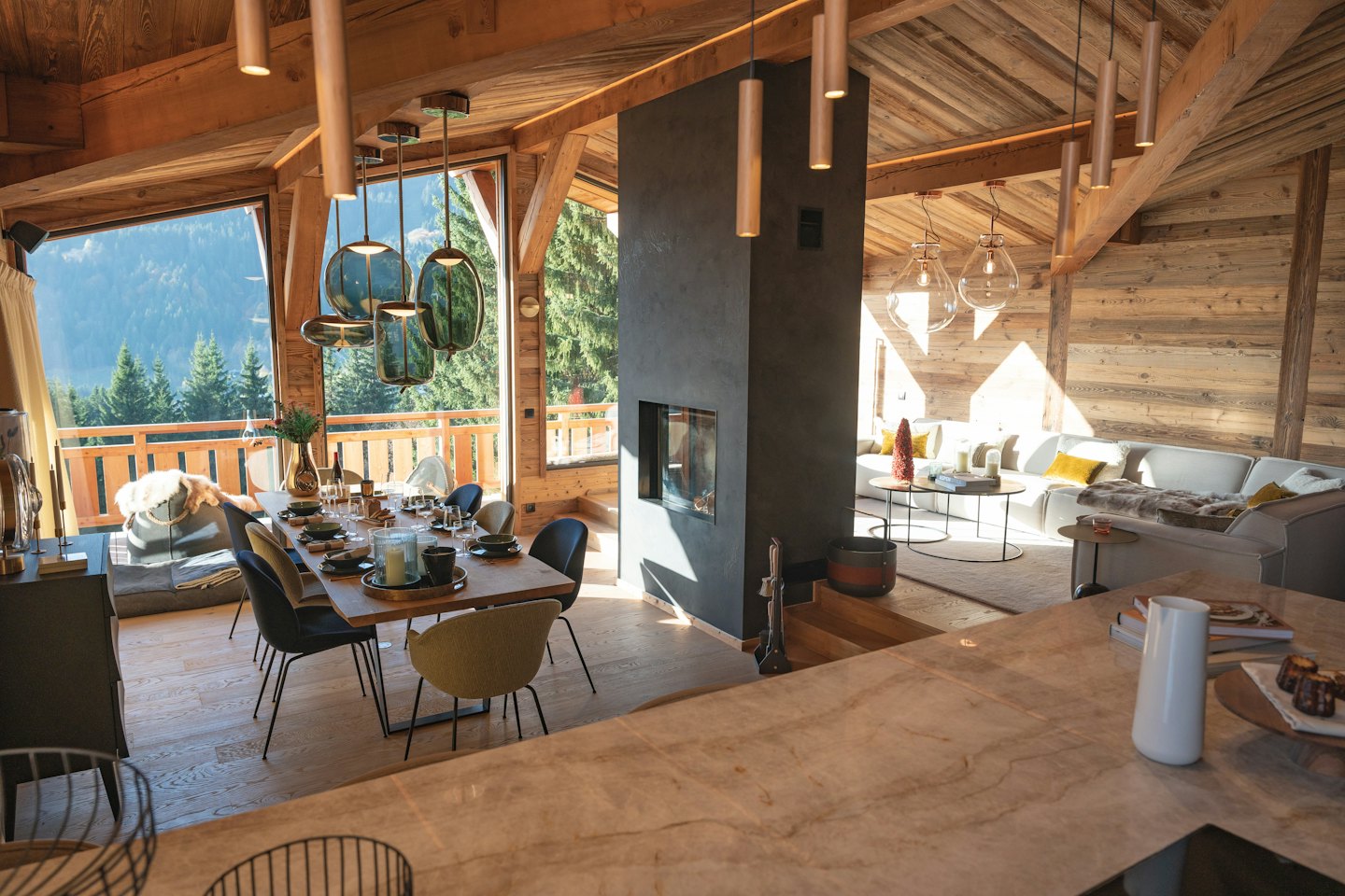 Salon de chalet moderne avec vue sur la forêt de pins et les montagnes.